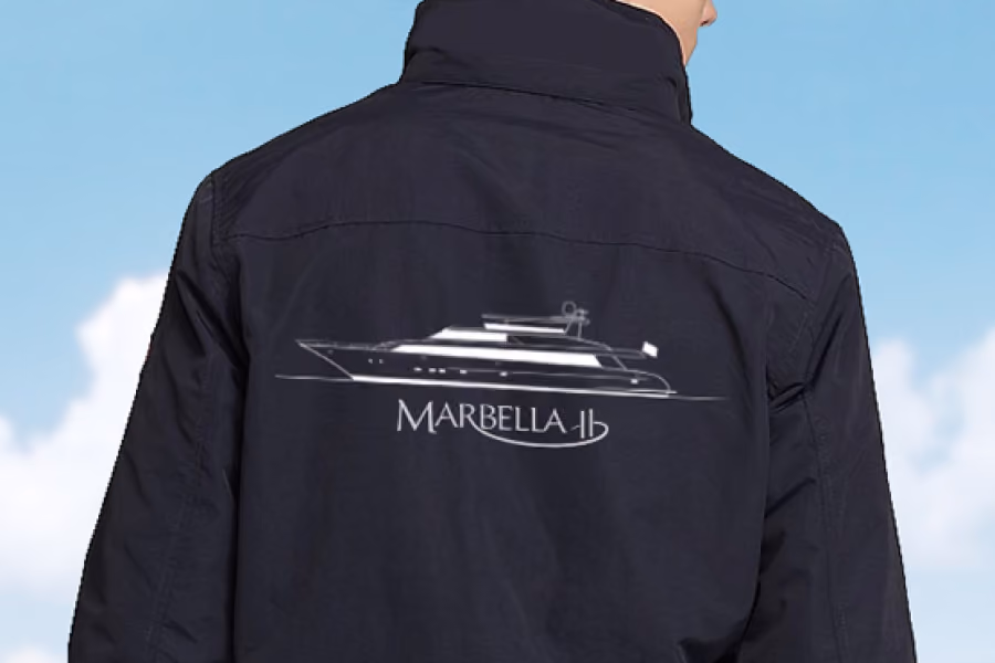 Person wearing a black jacket with a white yacht sketch and the text 'MARBELLA 11' on the back.