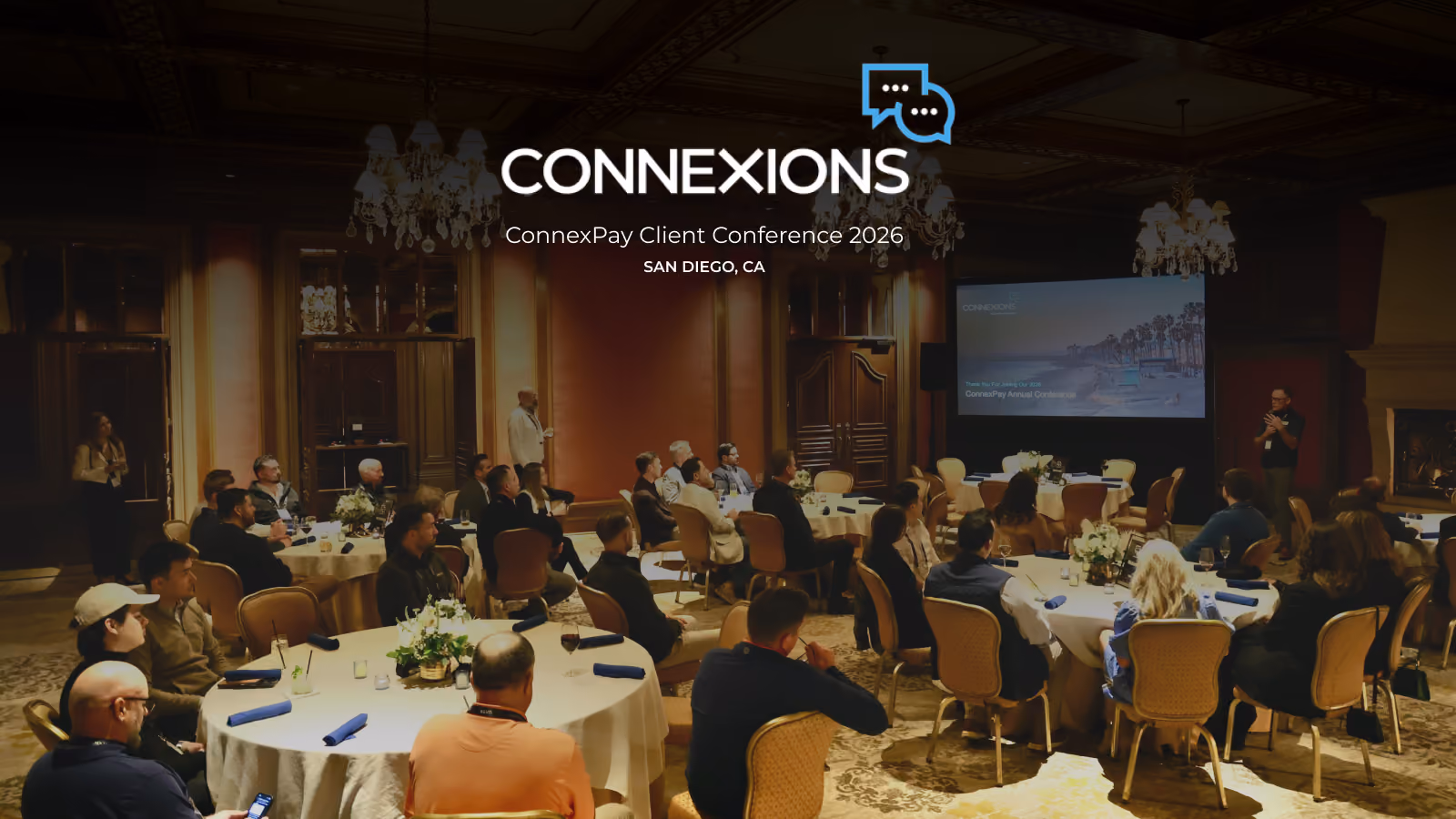 Audience seated at round tables listening to a speaker at ConnexPay Client Conference 2026 in San Diego.