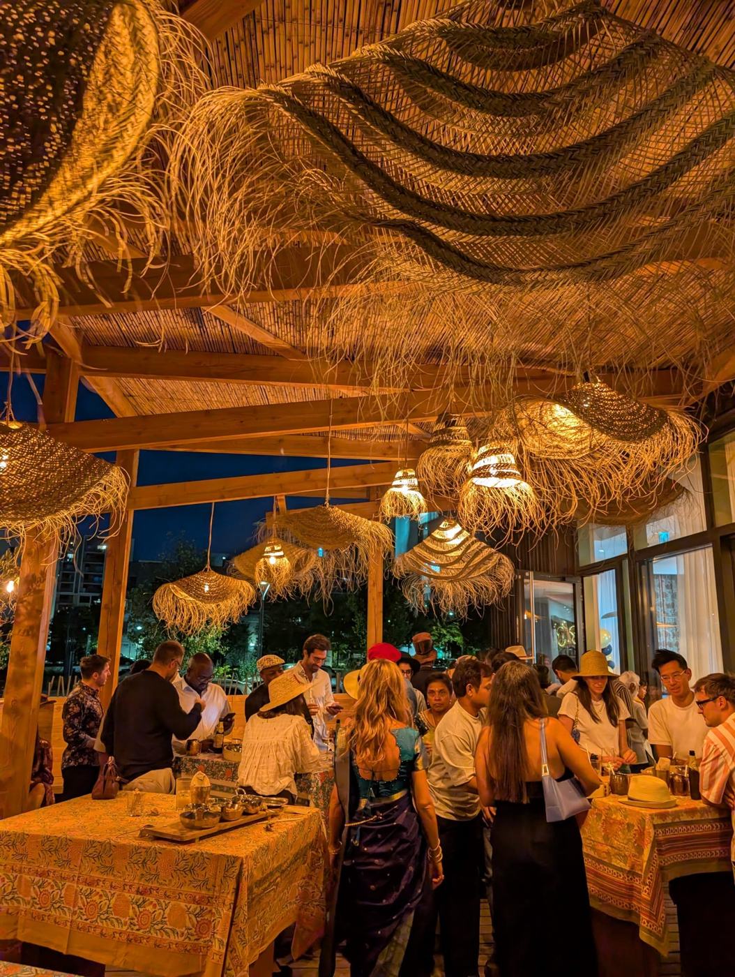 Soirée sur la terrasse du Bombay Talkies à Grenoble : convives sous la pergola et les lanternes en raphia