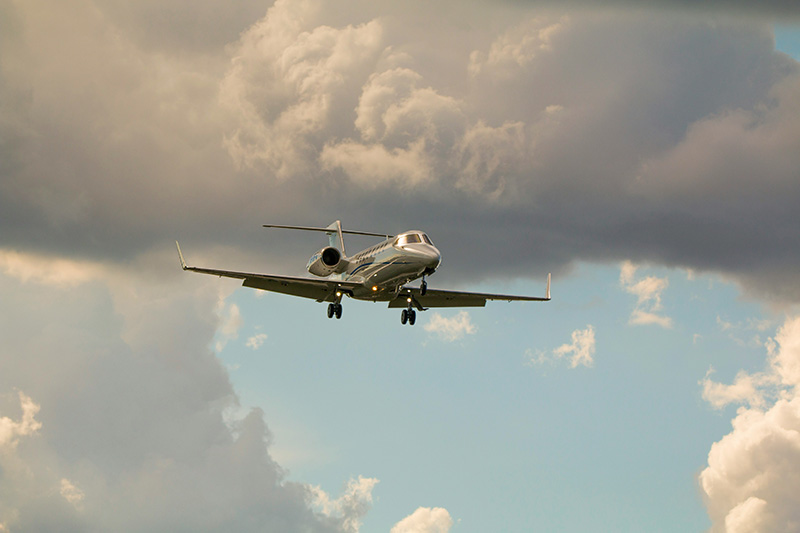 A private jet descends through the clouds.