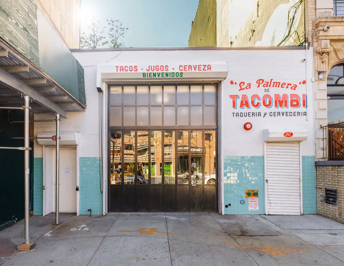Storefront of 'La Palmera de Tacombi' taqueria y cerveceria, with mint-green tiled base and large industrial windows