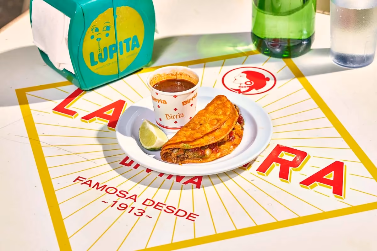 Beef birria taco with melted cheese, served with consomé for dipping