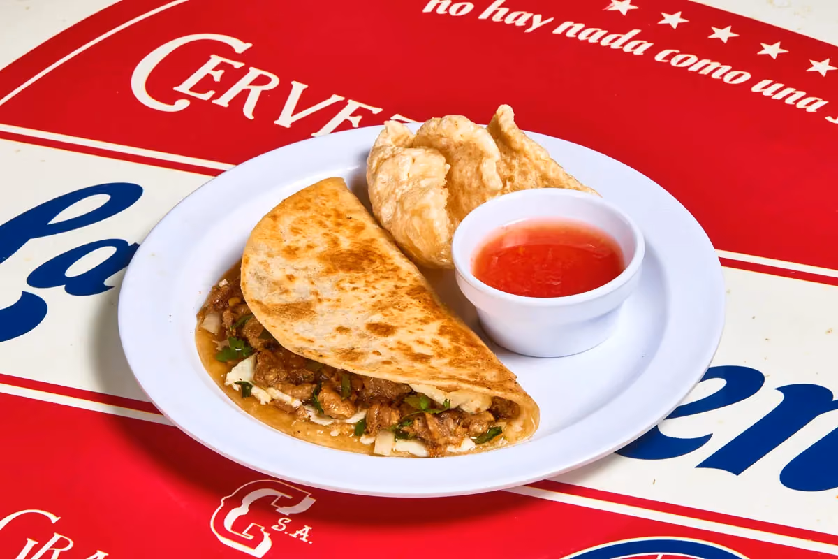 Carnitas quesadilla with melted cheese, cilantro, onion and crispy chicharrón