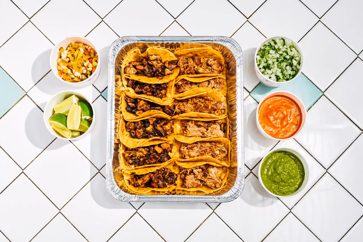 Taco Suprema set with 12 tacos and garnishes on the side