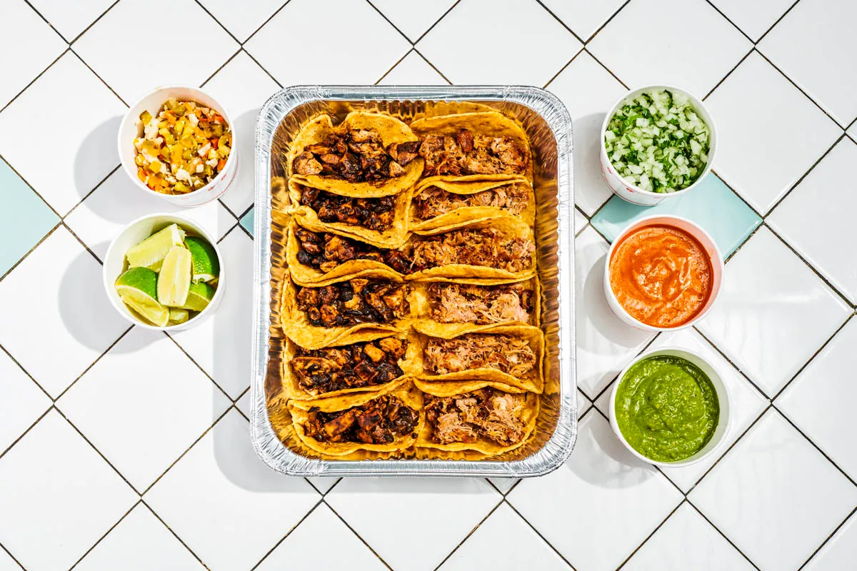 Taco Suprema set with 12 tacos and garnishes on the side