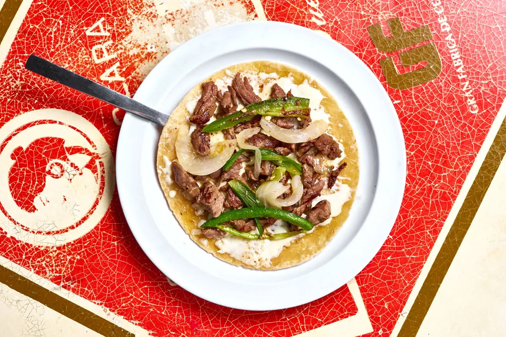 Carne asada quesadilla with caramelized onions, chiles toreados and melted cheese