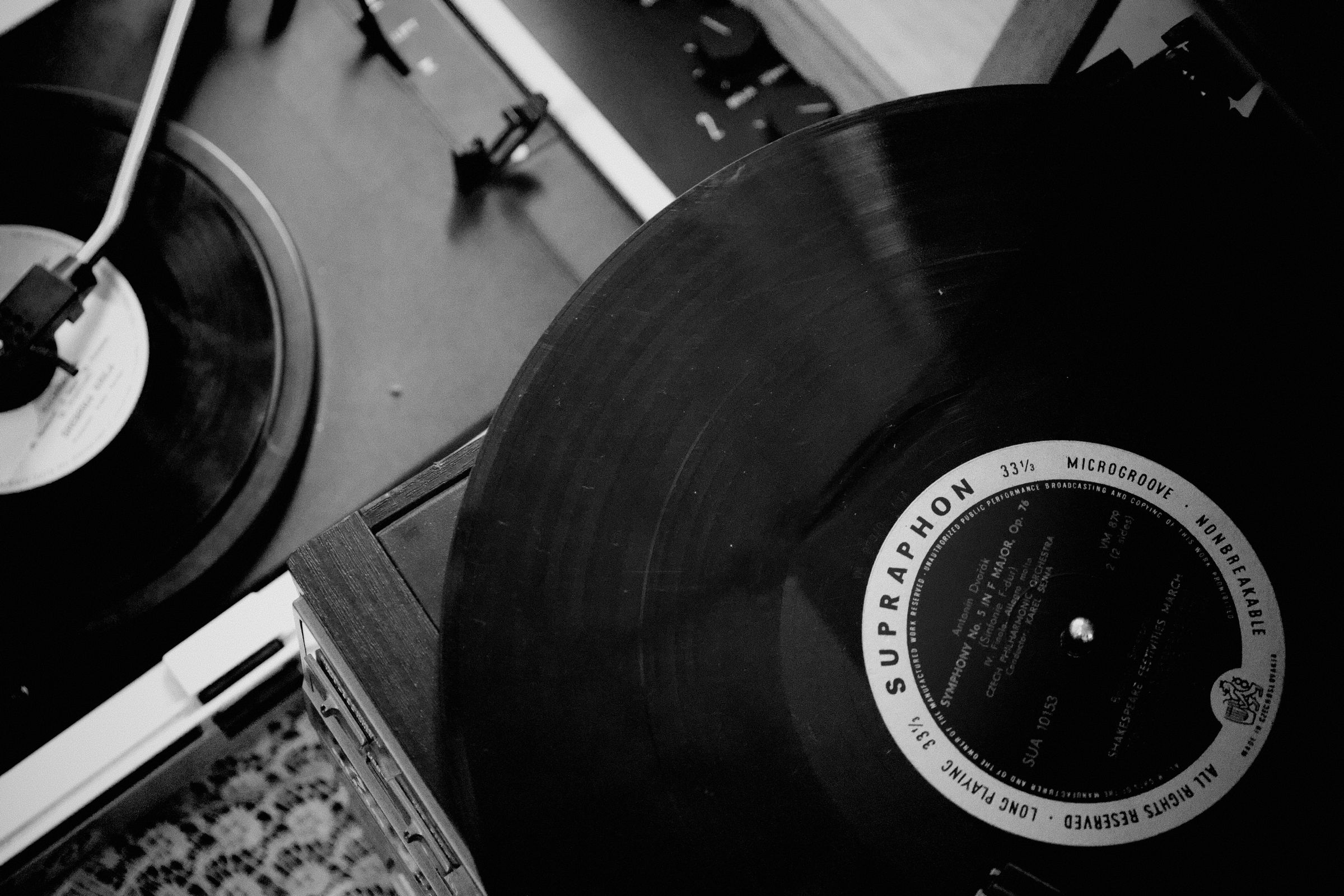 Deux disques vinyles sont joués sur des platines vintage en noir et blanc.