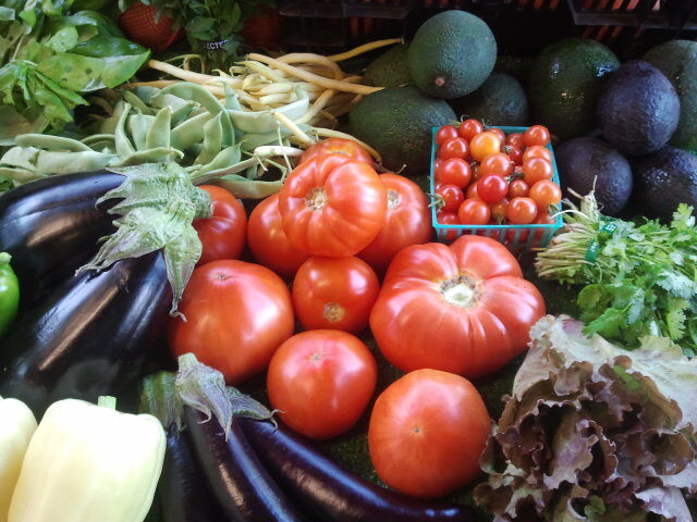 Heirloom tomatoes, eggplant and lettuce on the farmstand table at Eli's Farms