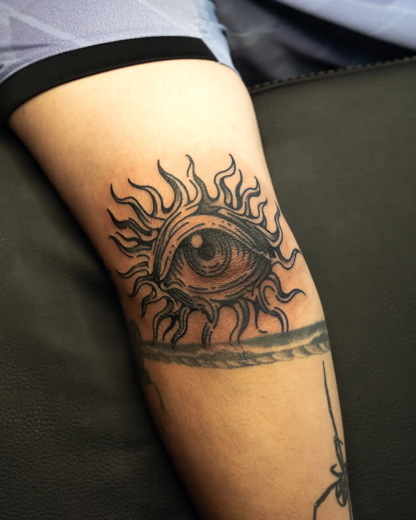 Black traditional eye tattoo on the elbow