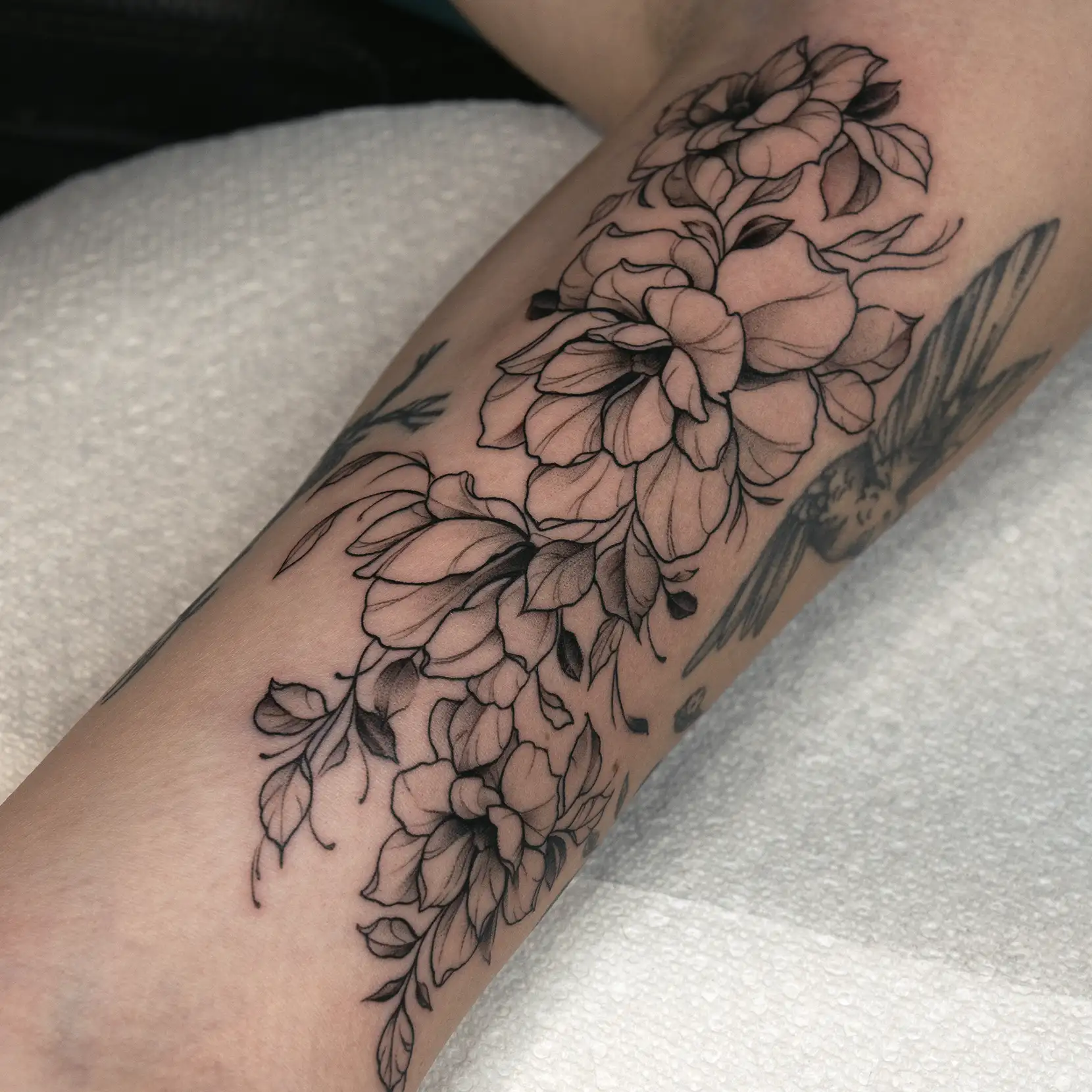 Fine-line minimalist floral tattoo