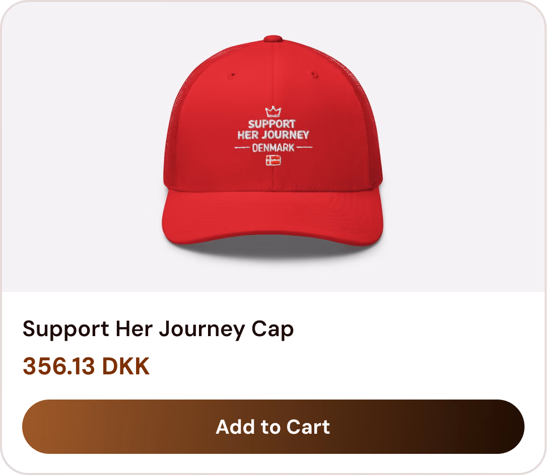 Red cap with white text 'Support Her Journey Denmark' and a small Denmark flag embroidered.
