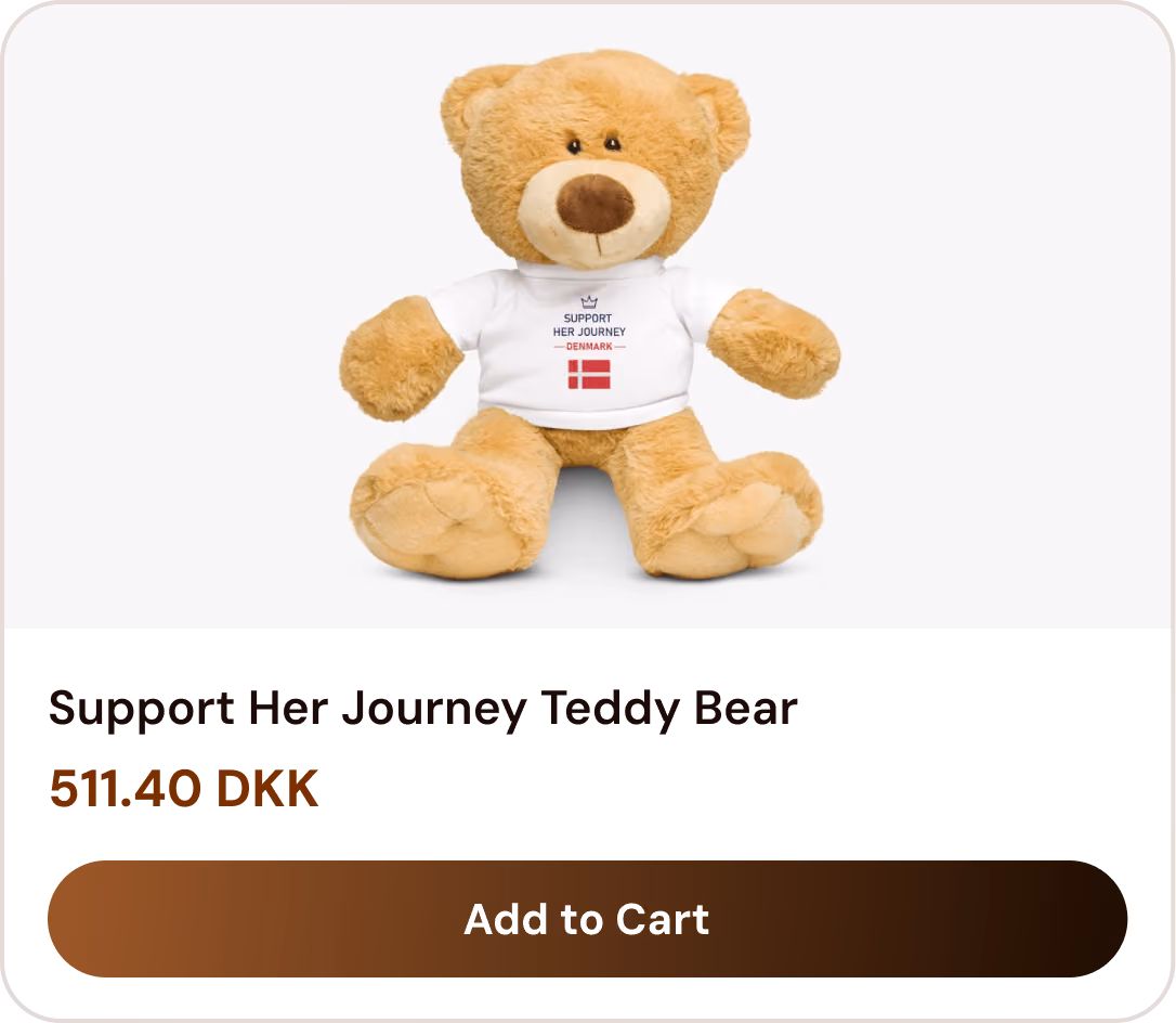 Tan teddy bear wearing a white shirt with 'Support Her Journey - Denmark' and a Danish flag.