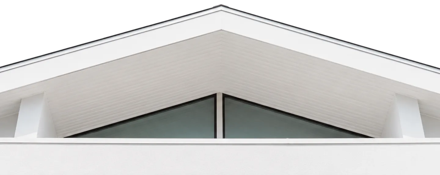 Close-up of a modern white building roof with a triangular glass window below the eaves.