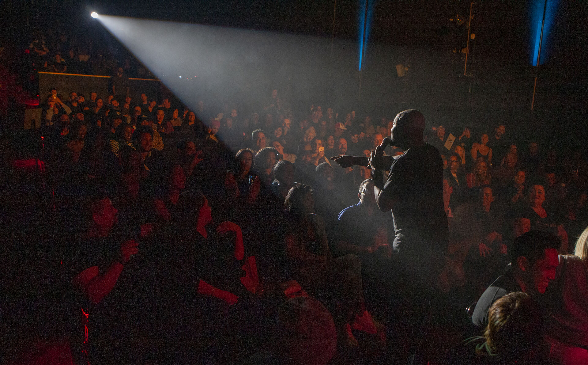 A packed house watching a performer from the floor