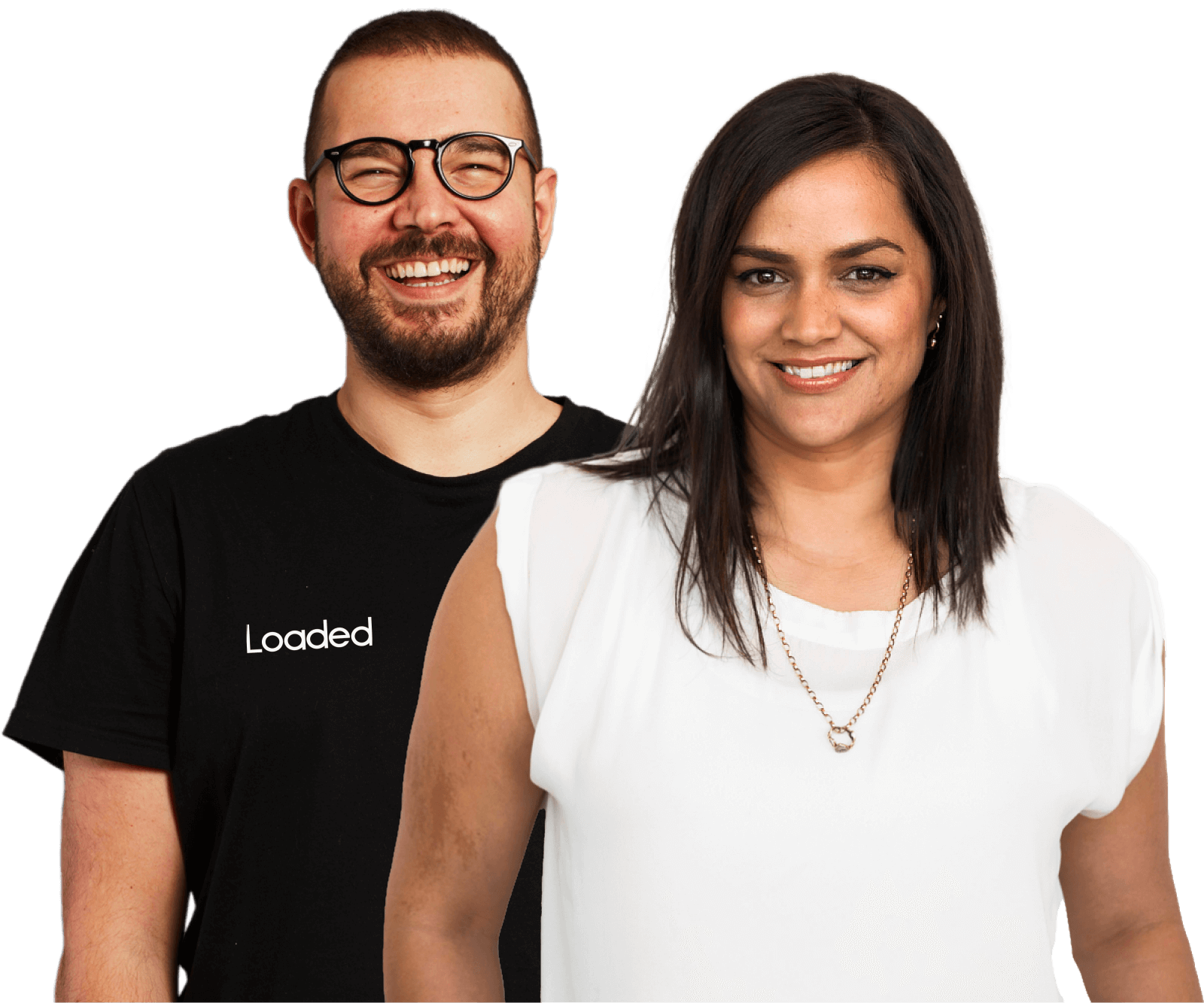 Smiling man with glasses wearing a black Loaded t-shirt stands behind a smiling woman in a white blouse with a necklace.