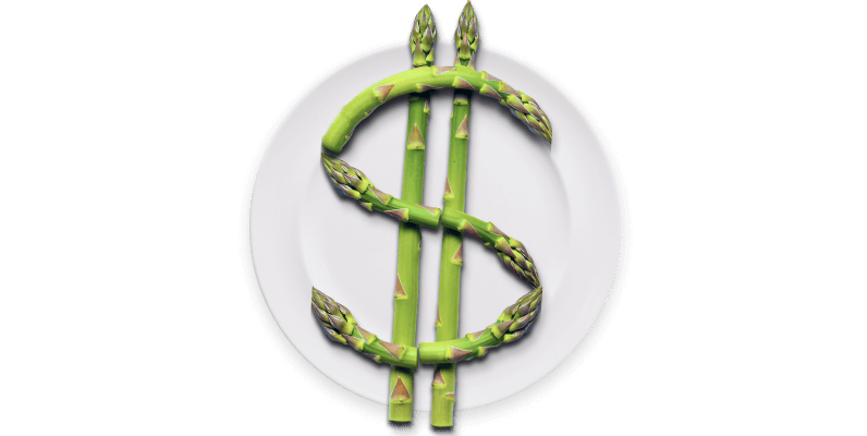 White plate with green asparagus arranged in the shape of a dollar sign.