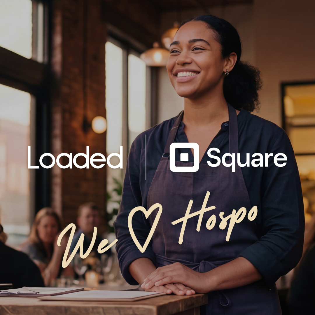 Smiling waitress in a dark apron standing at a table in a warmly lit restaurant with the text 'Loaded | Square' and handwritten 'We ♥ Hospo' overlay.