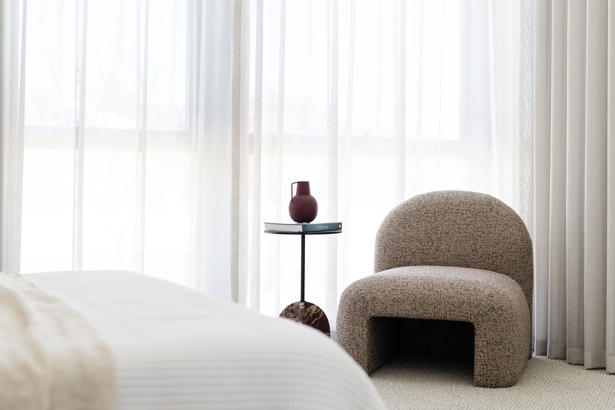 Boucle armchair and side table styled beside a curtained window in a Perth home
