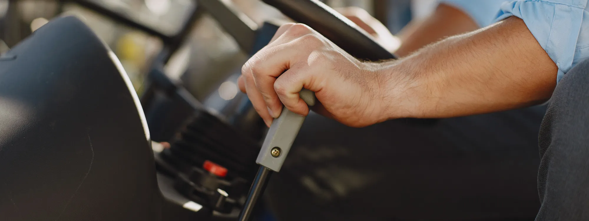 Close-up of a person’s hand gripping a gearstick inside a vehicle.