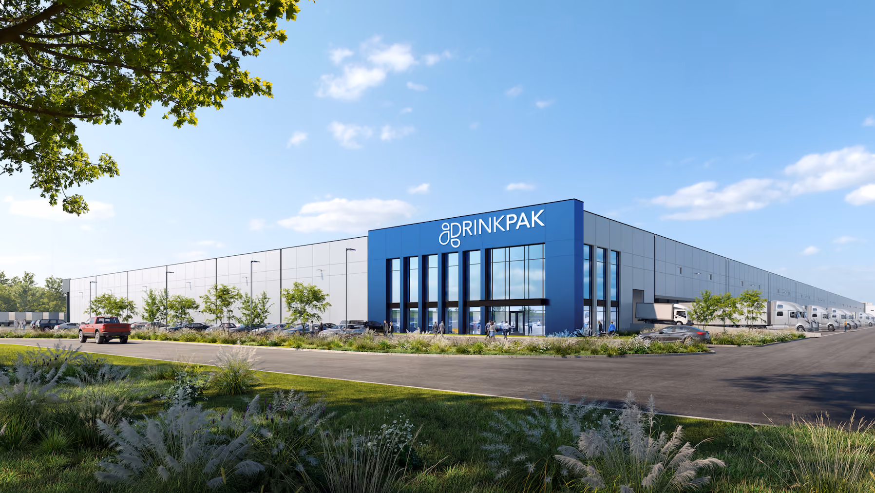 Modern Drinkpak building with blue entrance, parking, trucks, and green landscaping under a clear sky.