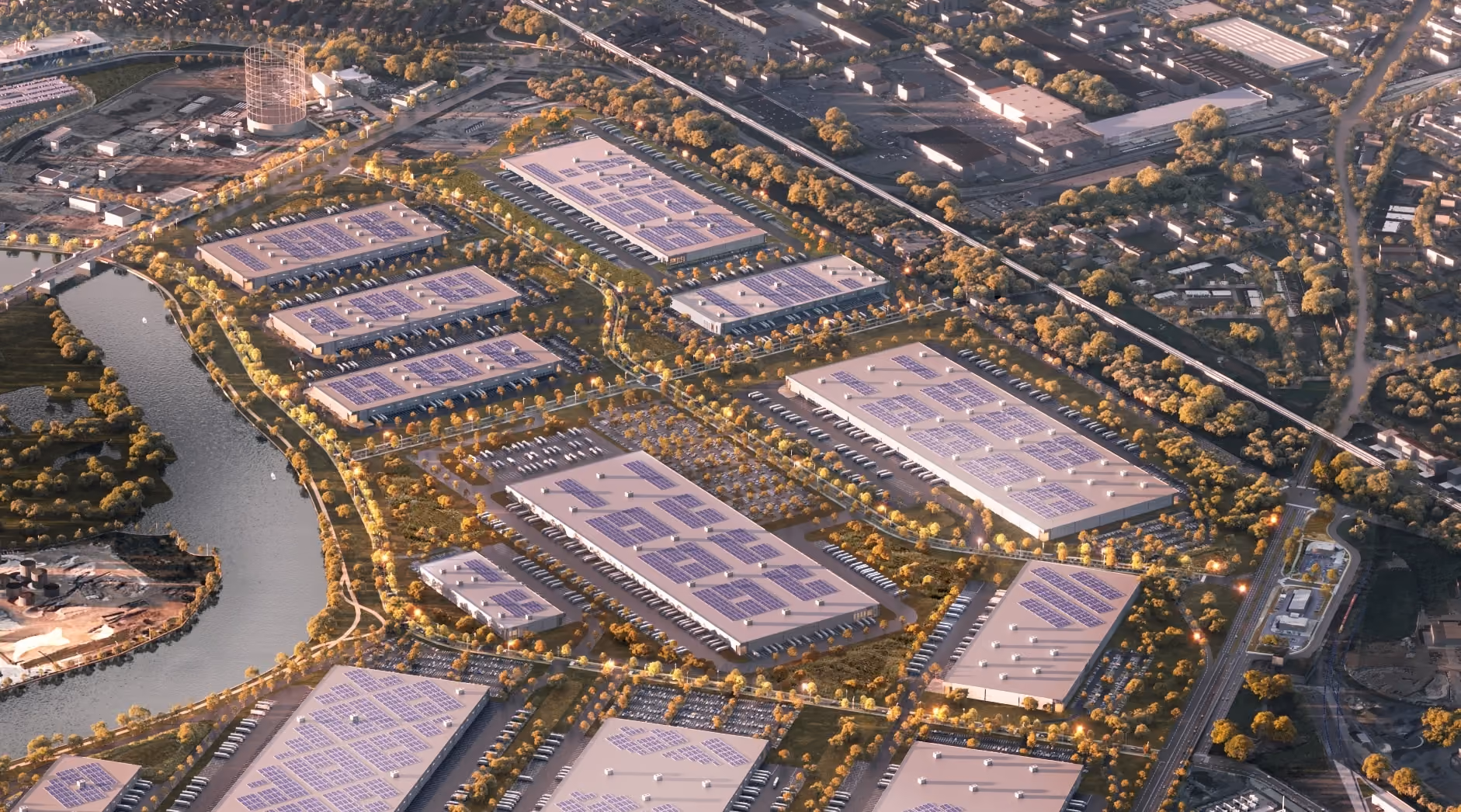 Aerial view of an industrial park with solar panels on warehouse roofs near a river.
