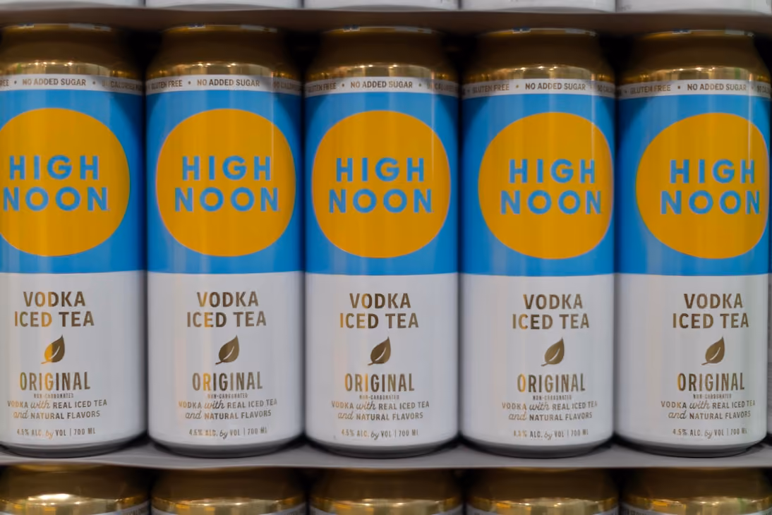 Five cans of High Noon Vodka Iced Tea Original flavor lined up on a shelf.
