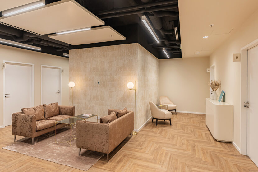 Wartebereich mit Sofas und Natursteinwand im Facharztzentrum Magna Med