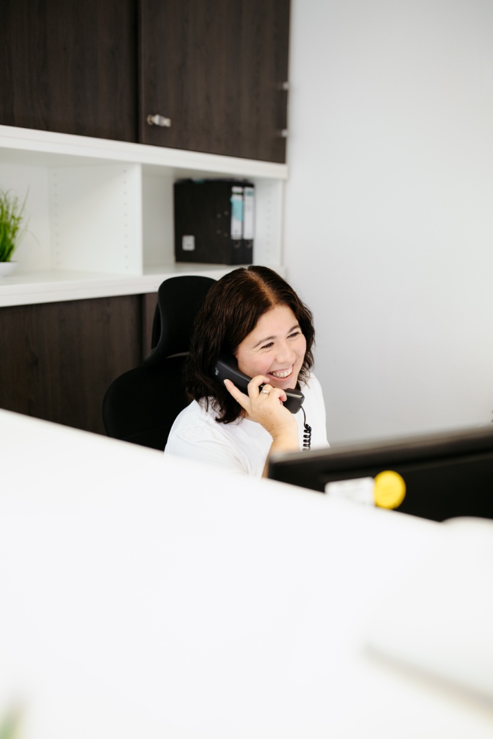 Mitarbeiterin telefoniert am Arbeitsplatz