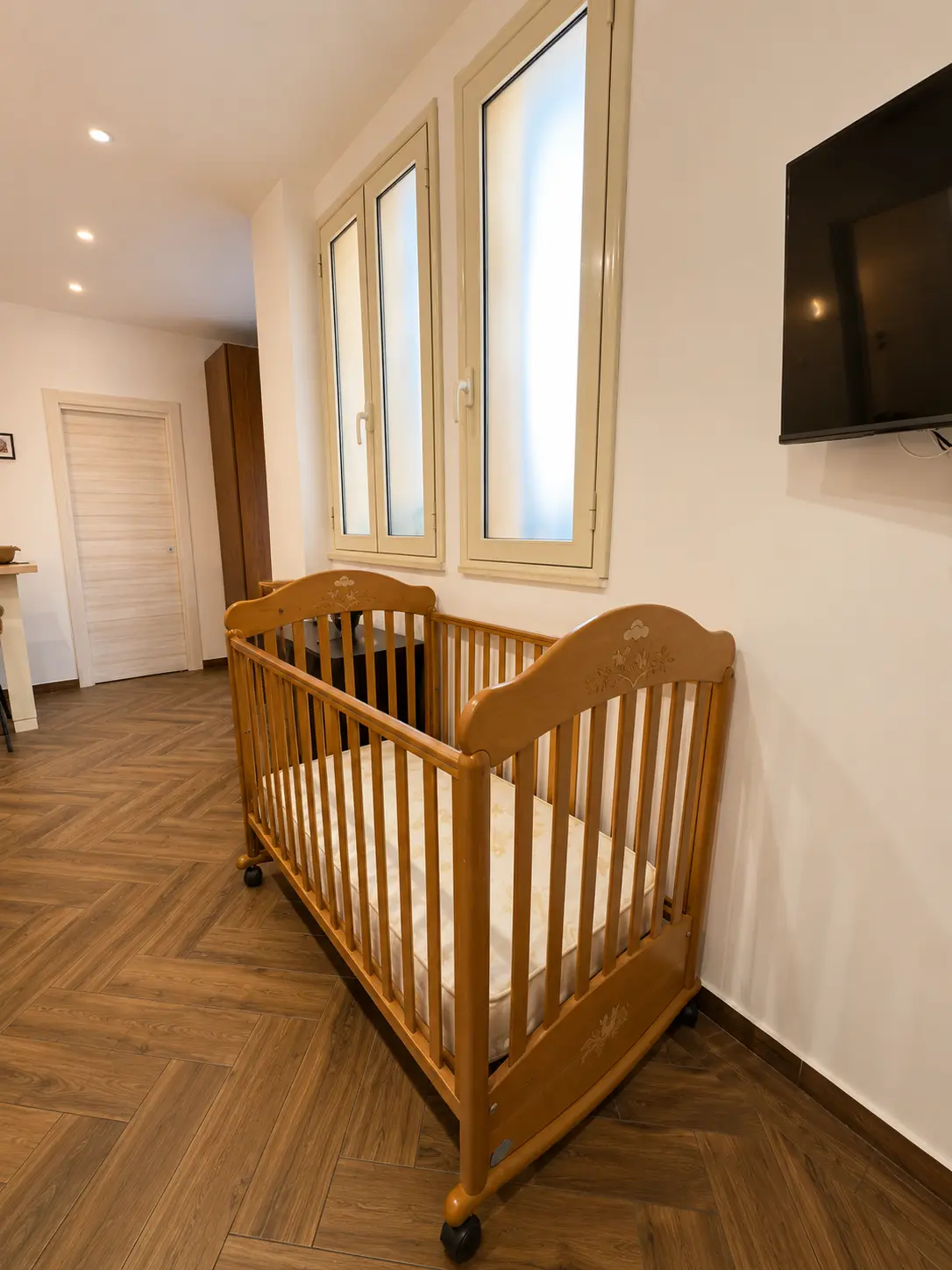 Camera elegante e accogliente con letto matrimoniale, letto singolo e culla, ideale per coppie e famiglie che cercano comfort e relax.