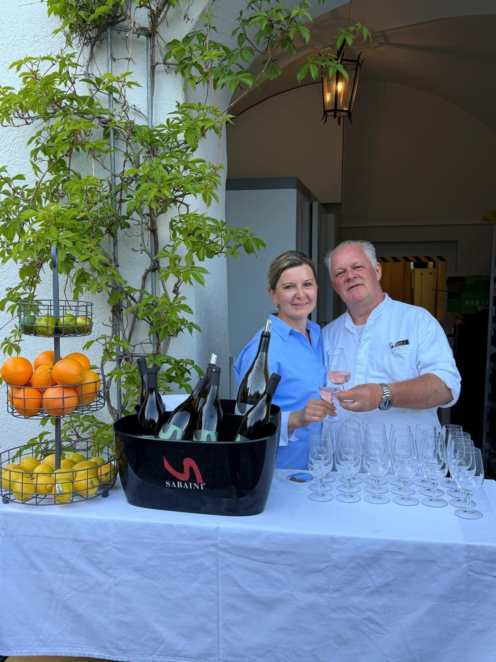 Das Serviceteam des Schlossrestaurants in Hosenträgern vor der Schlossmauer