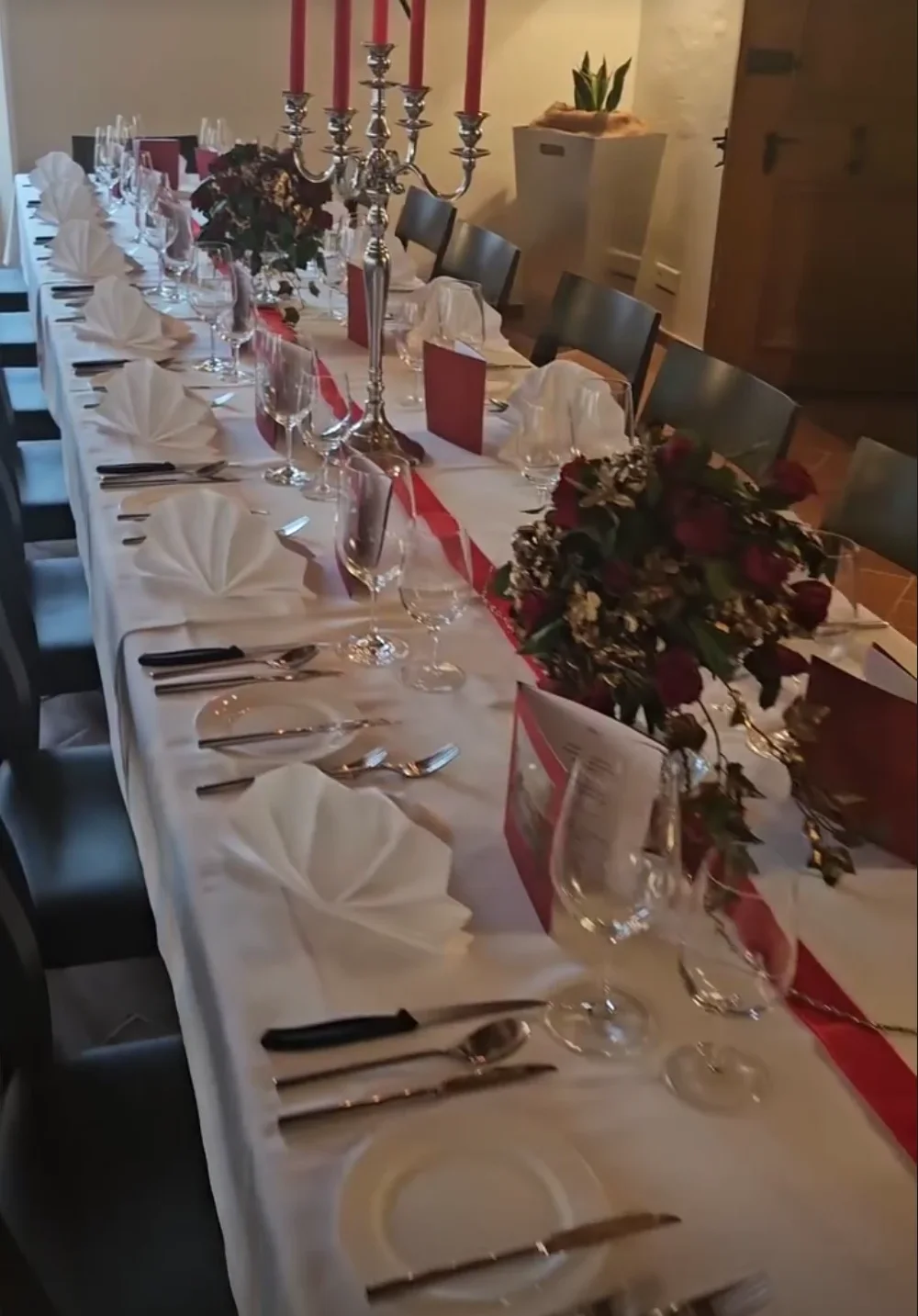 Festlich gedeckte Bankett-Tafel mit Kerzenleuchter und Rosen
