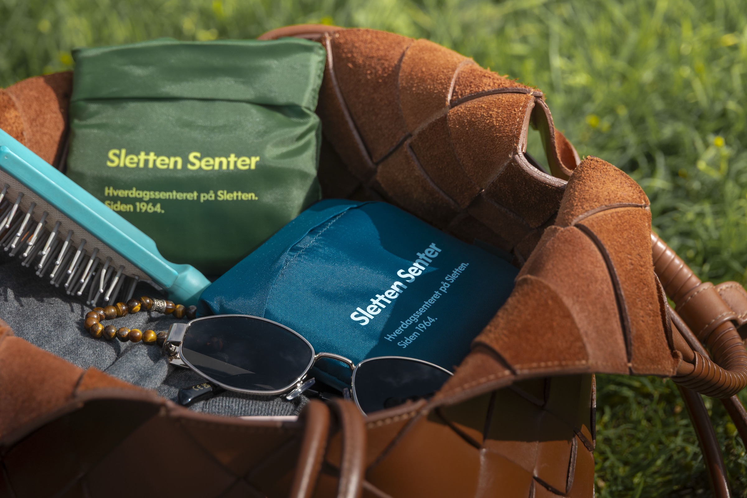 Sletten Senter-handlenett i grønt og blått i en veske på gresset