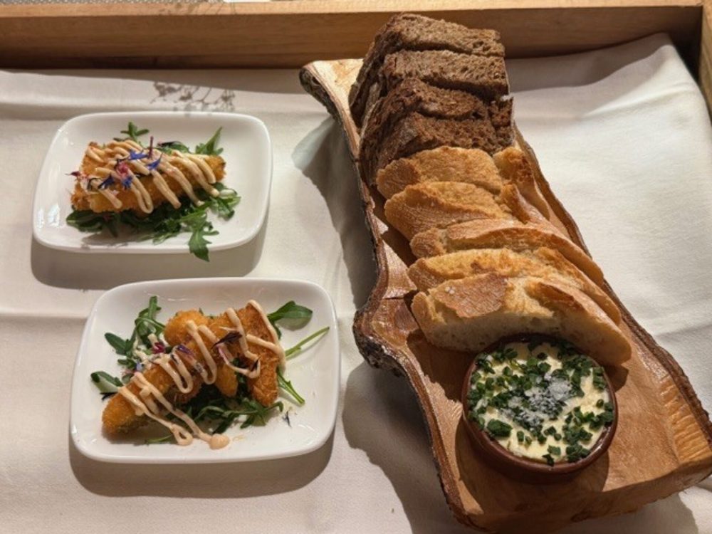 Amuse-Bouche mit hausgemachtem Brot auf Holzbrett