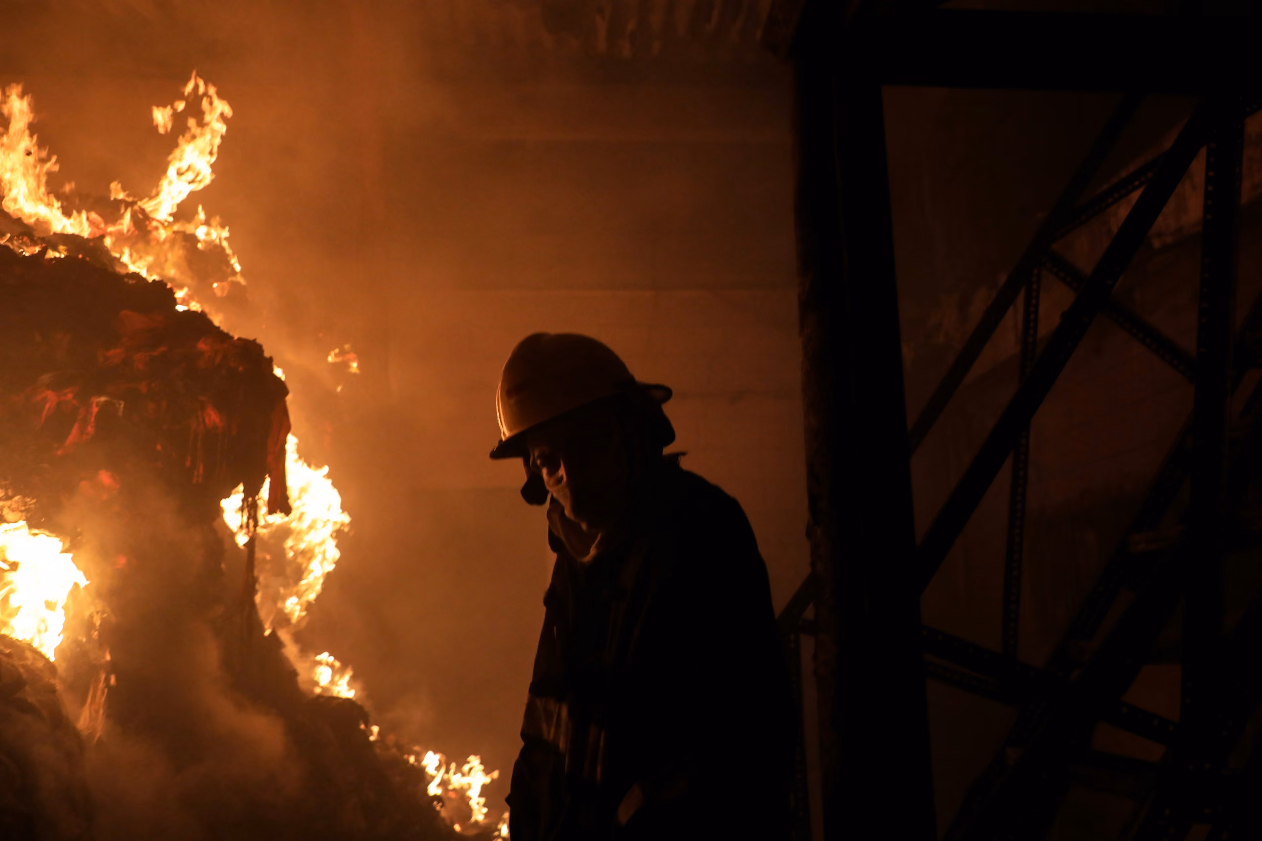 Silhouette of a firefighter against the glow of a fire
