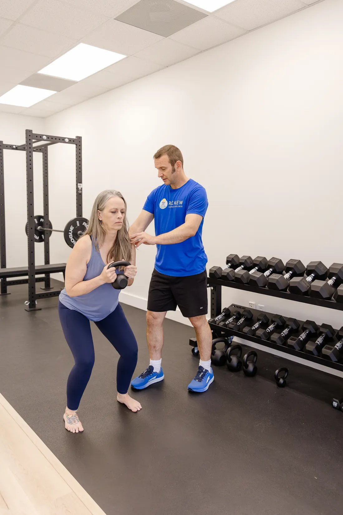 Matt Rieder, DPT, coaching a patient's squat in the Renew gym in St. Augustine, FL