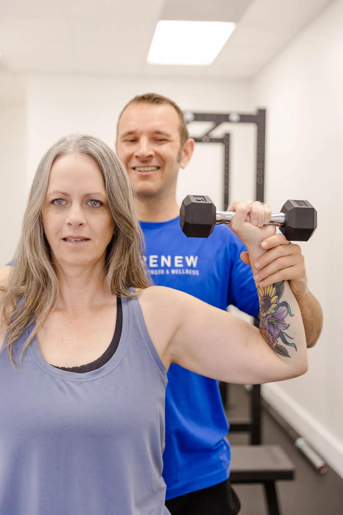 Matt Rieder, DPT, coaching a patient through a dumbbell shoulder press at Renew Strength & Wellness in St. Augustine, FL