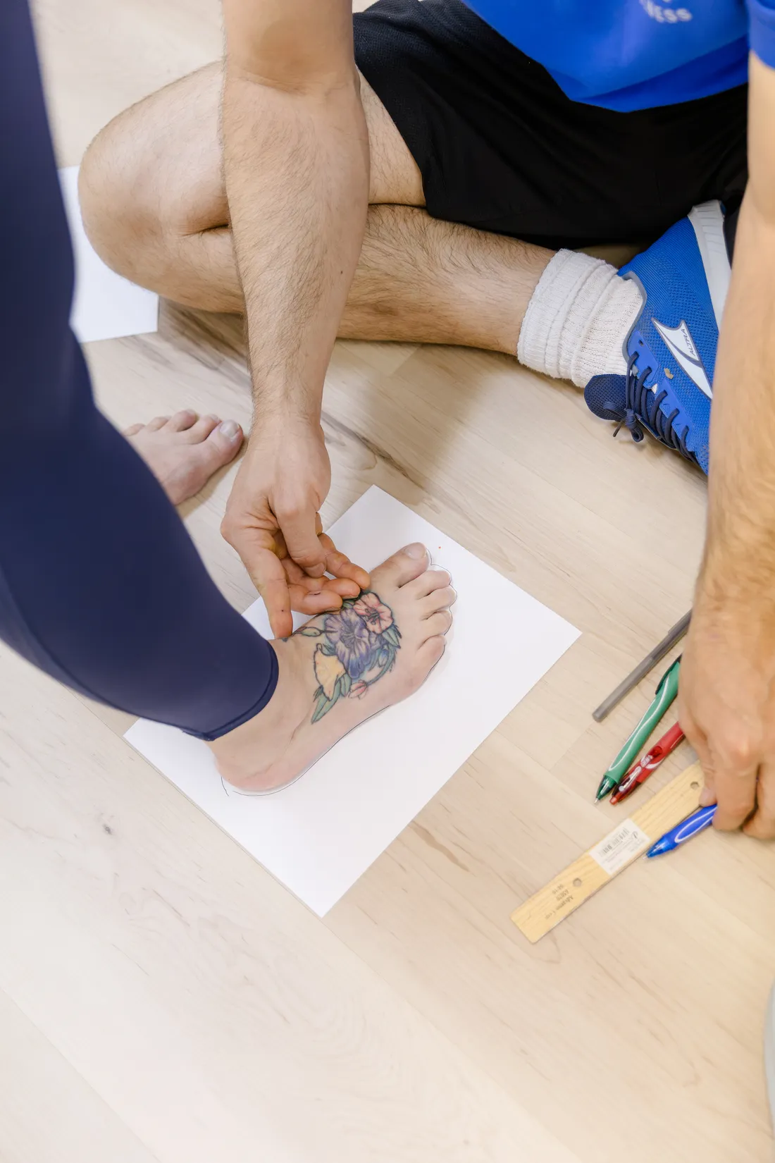 Tracing a patient's foot on paper to check how the foot moves, at Renew Strength & Wellness in St. Augustine, FL
