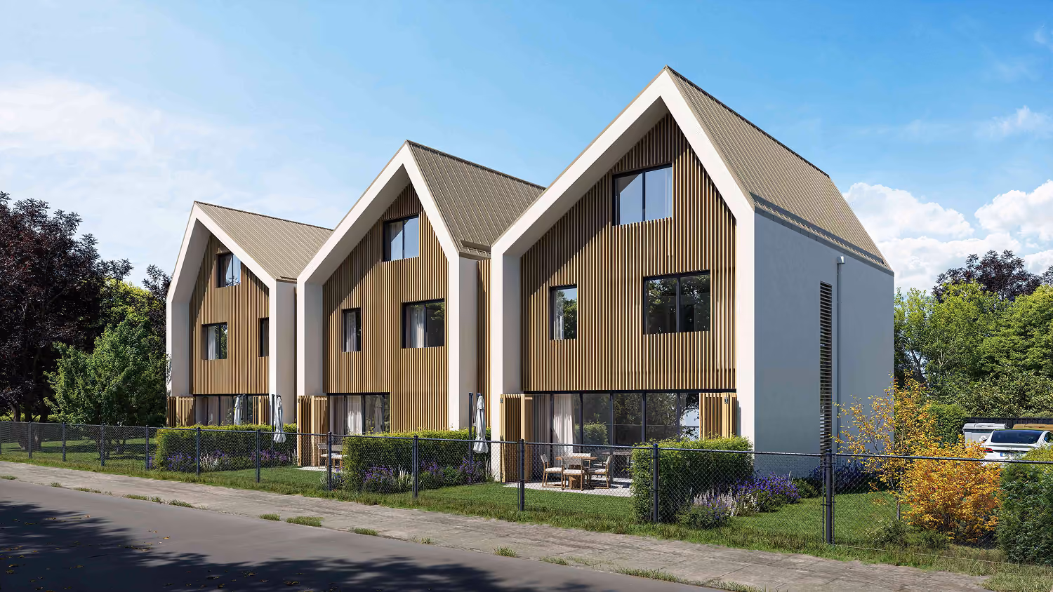 Trois maisons modernes avec façades boisées, grands vitrages, jardin et clôture métallique.
