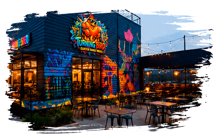 Outdoor dining area with tables and chairs outside a colorful mural-covered restaurant at dusk.