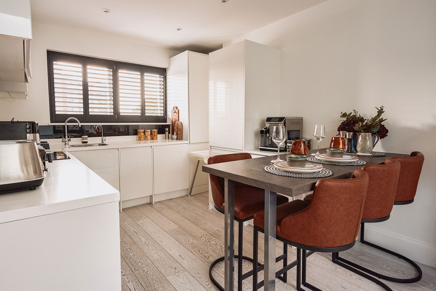 Top-of-the-line appliances, including a dishwasher, oven and coffee maker, with a dining table for shared meals.