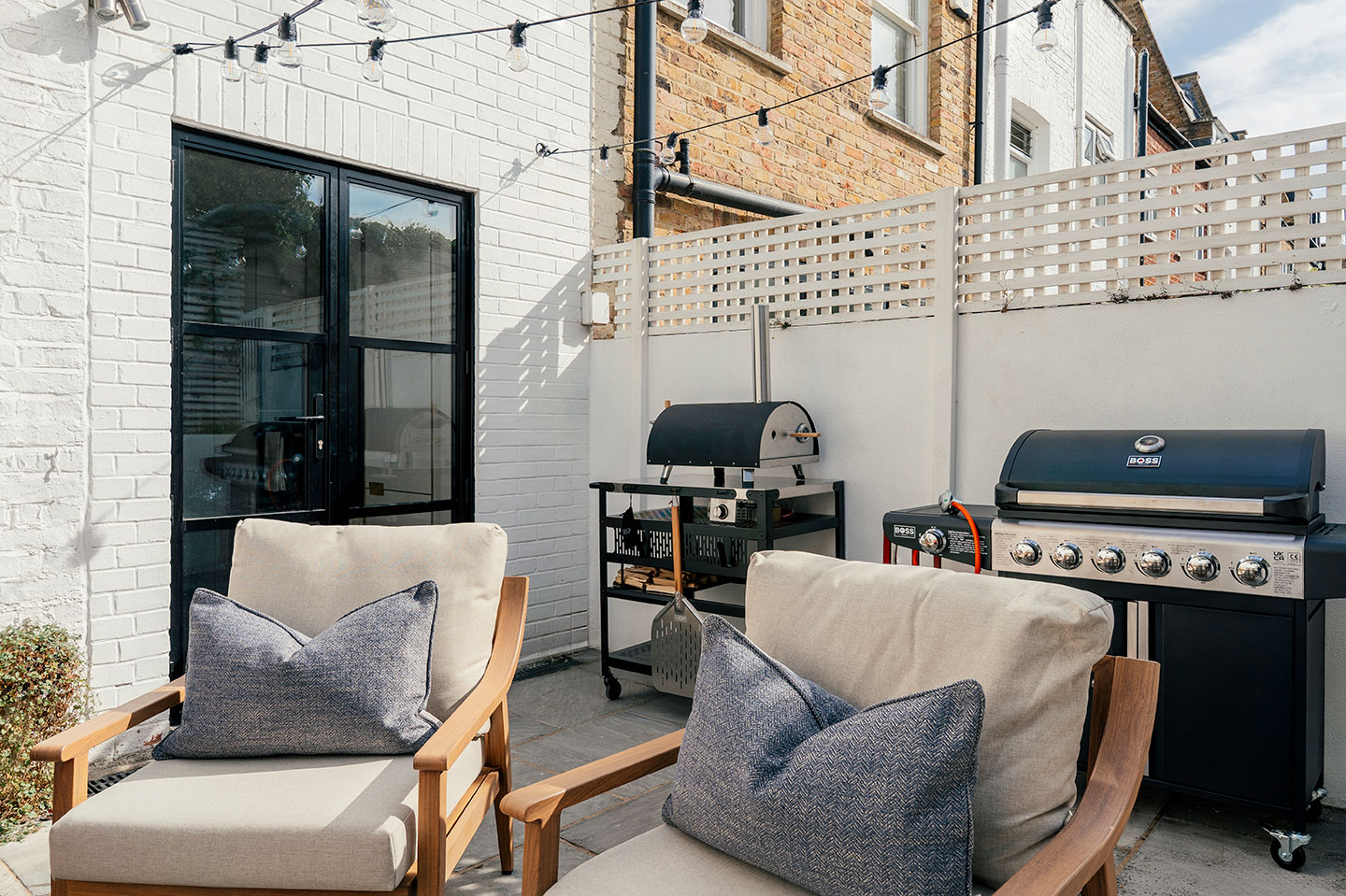 Private garden patio with a BBQ grill, perfect for alfresco dining and outdoor relaxation.