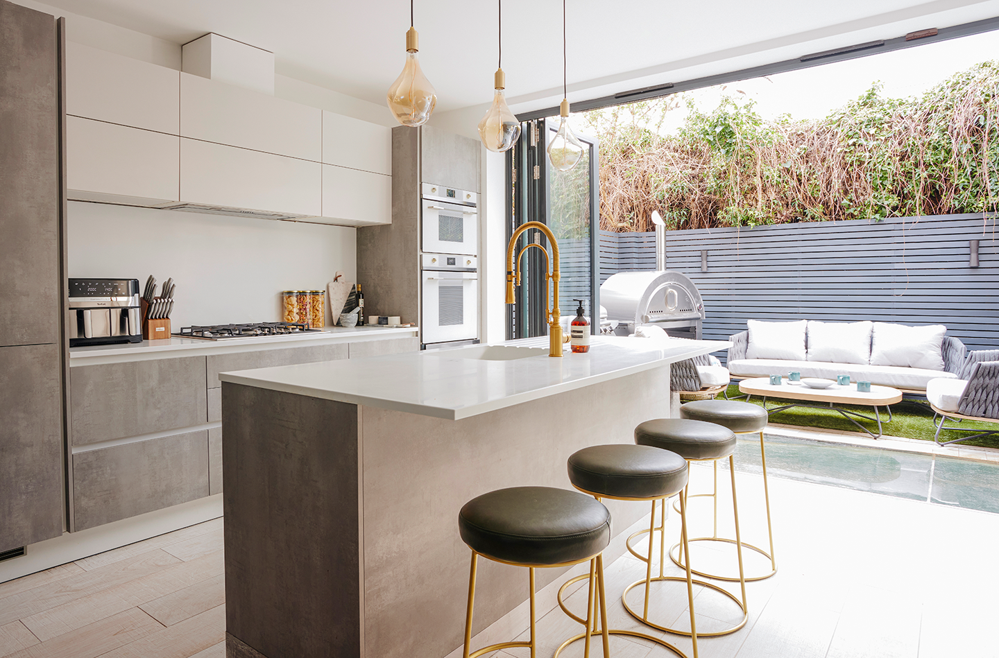 A stainless steel double oven, gas stove and dishwasher, with a dining table for long family meals.