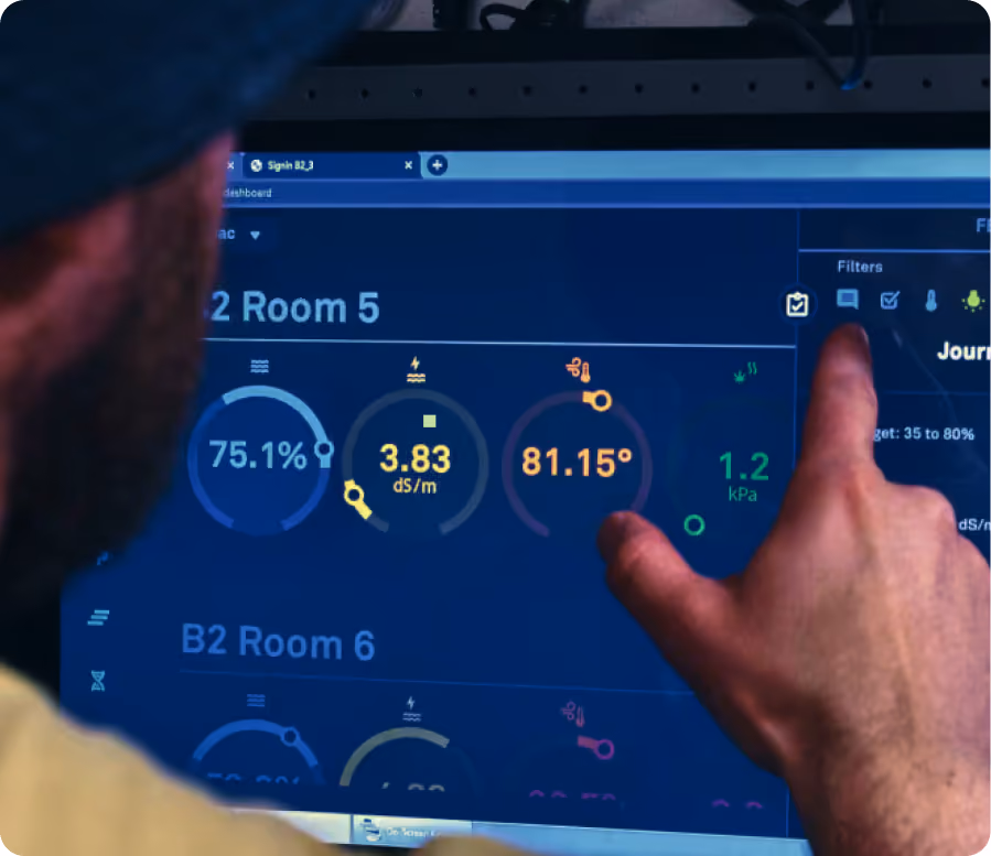 Grower pointing at room metrics on the AROYA dashboard during an expert session