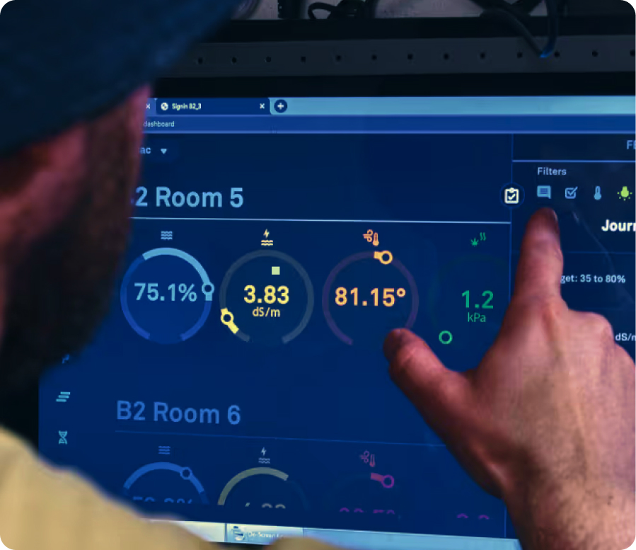 Grower pointing at room metrics on the AROYA dashboard during an expert session