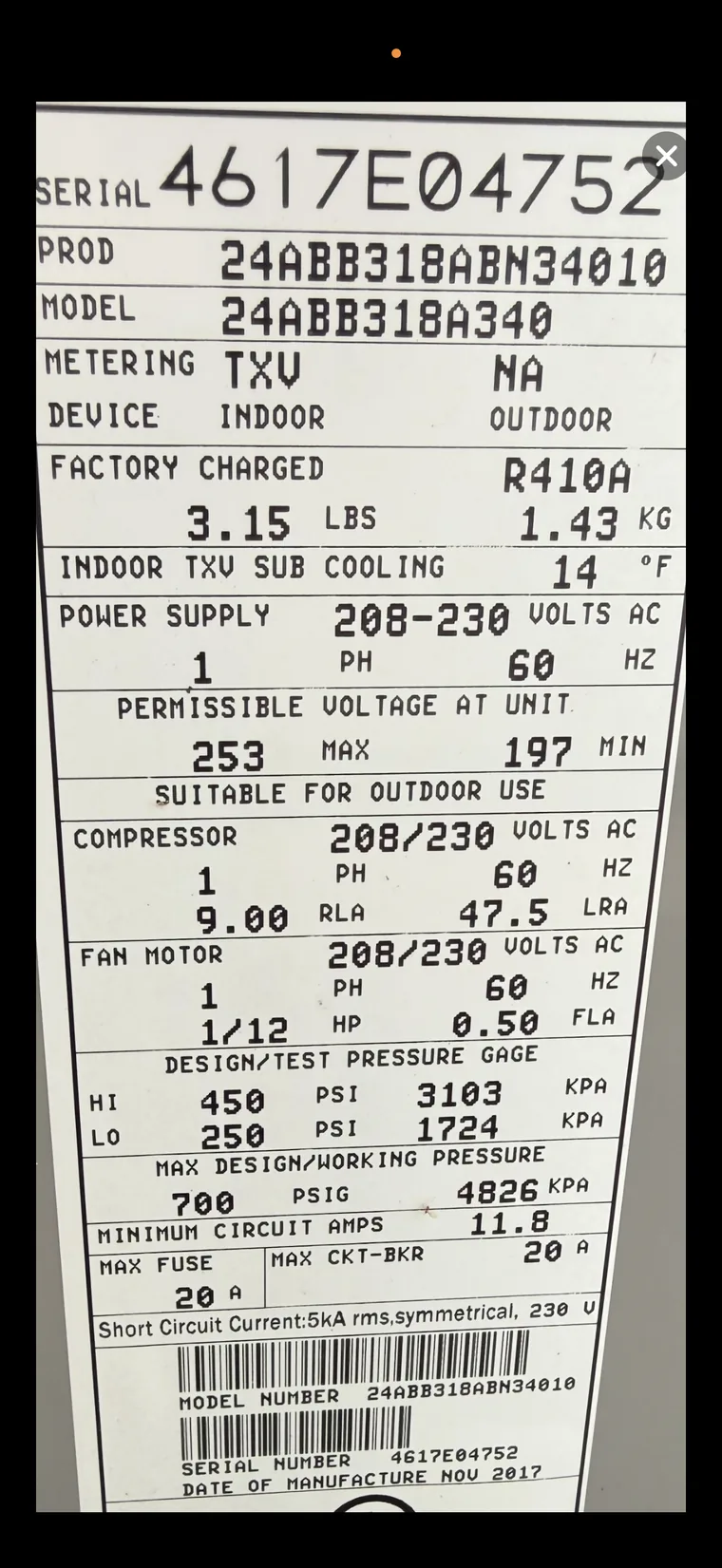 Photo of a Carrier condensing unit nameplate showing serial, model, and electrical specs