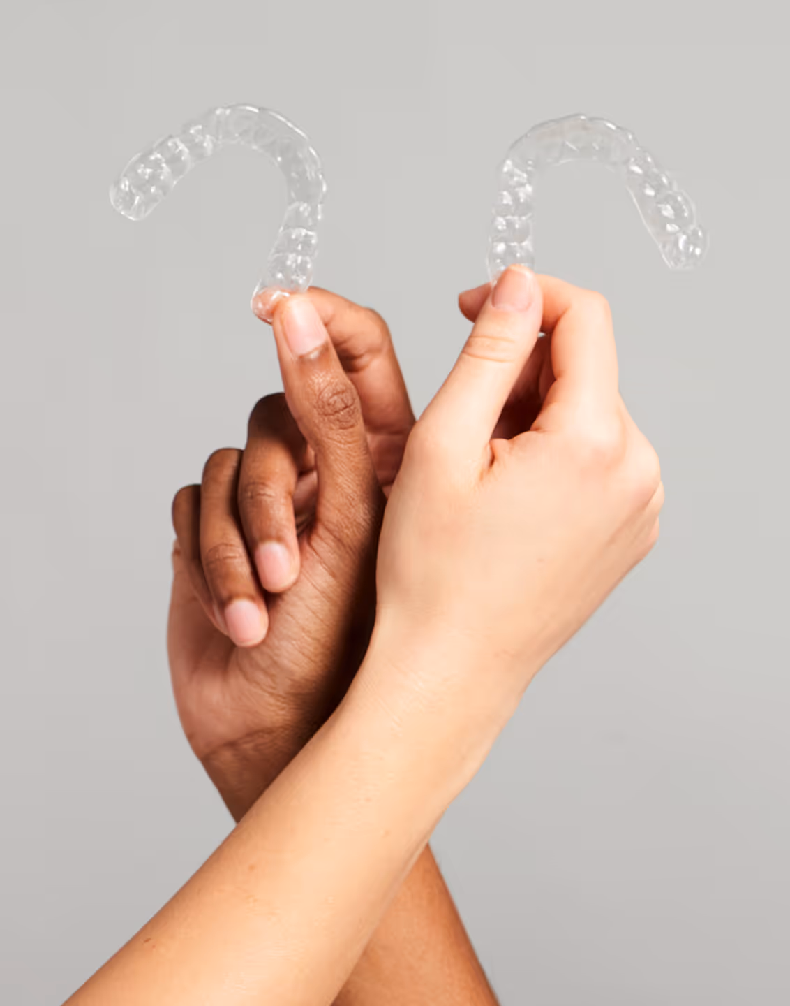 Une personne avec des gants bleus tient un cadre transparent devant le visage souriant d'une femme blonde.