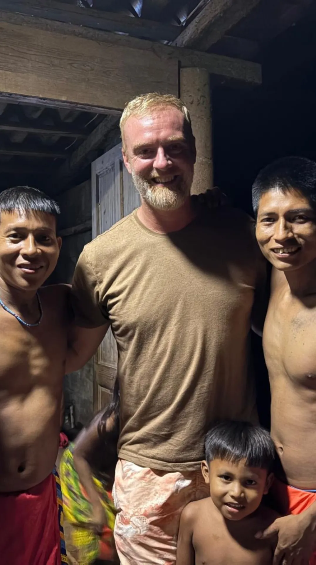 Cinq hommes souriants posant ensemble à l'intérieur d'une structure en bois après une partie de Pêche au Panama