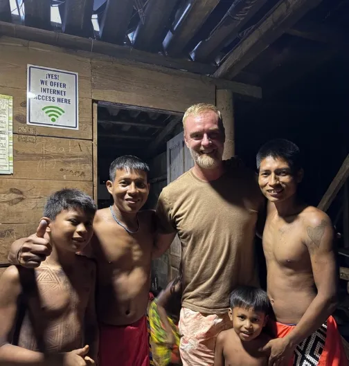Cinq hommes souriants posant ensemble à l'intérieur d'une structure en bois après une partie de Pêche au Panama