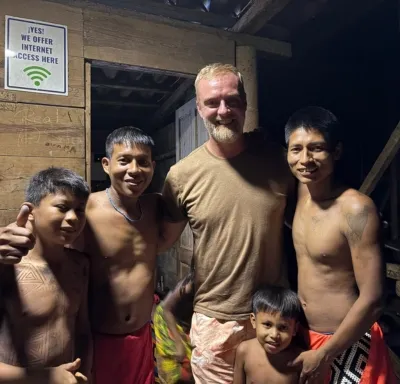 Cinq hommes souriants posant ensemble à l'intérieur d'une structure en bois après une partie de Pêche au Panama
