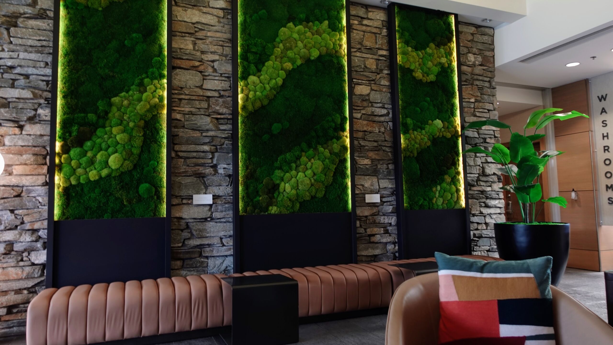 Preserved moss wall panels and leather bench seating in the Sidney Pier hotel lobby